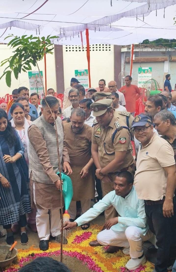 वृक्षारोपण कार्यक्रम में पौधे को जल अर्पित करते अतिथि
